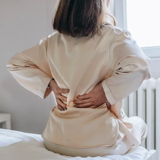 Physiotherapist assisting patient with back pain treatment at Violet Physio